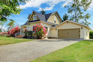 Yellow house exterior with spring blooming rhododendron