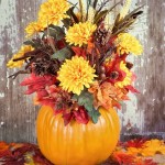 Fall centerpiece made with pumpkin, flowers, and leaves